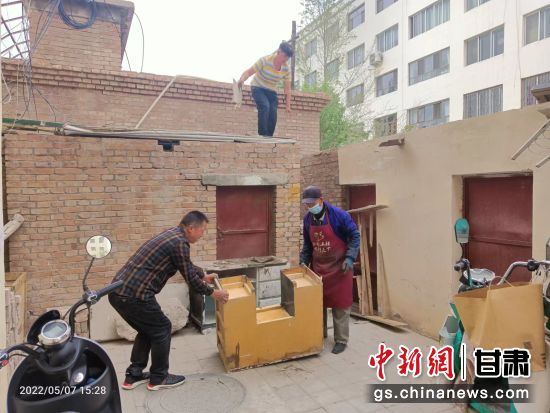 图为玉门市新市区街道志愿者清扫背街小巷卫生。